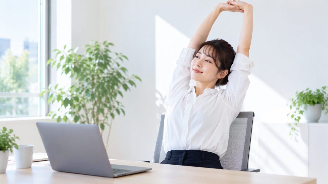 デスクワークの合間に背伸びをする女性のイメージ