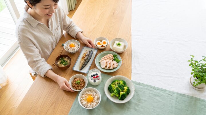 代謝を支える食材が並ぶ食卓を整える女性